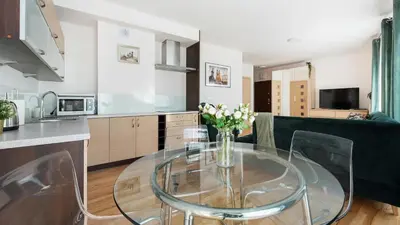 a kitchen with a glass table with a vase of flowers at Angel City, Sun & Snow in Kraków