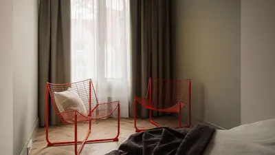 two red chairs sitting in front of a window at Kossak Residence, Sun & Snow in Kraków