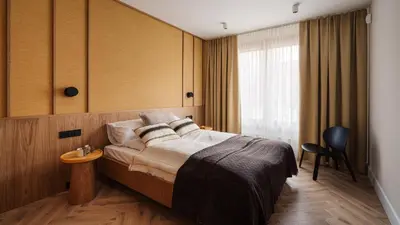 a hotel room with a bed and a chair at Kossak Residence, Sun & Snow in Kraków