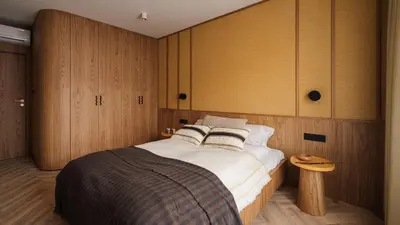 a bedroom with a large bed and wooden cabinets at Kossak Residence, Sun & Snow in Kraków