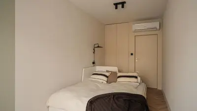 a bedroom with a bed with white sheets and pillows at Kossak Residence, Sun & Snow in Kraków