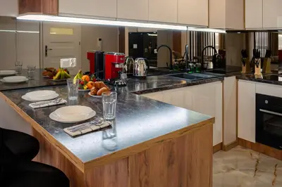 a kitchen with a counter with plates and glasses on it at Ekskluzywny apartament + garaż in Kraków