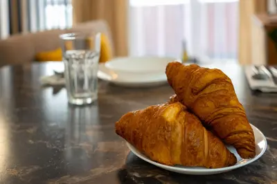 two croissants sitting on a plate on a table at Ekskluzywny apartament + garaż in Kraków