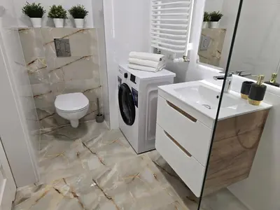 a bathroom with a washing machine and a sink at Ekskluzywny apartament + garaż in Kraków