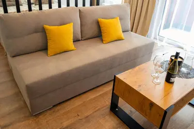a couch with two yellow pillows and a table at Ekskluzywny apartament + garaż in Kraków