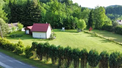 a small house in the middle of a green field at Mogielicki Zakątek in Jurków