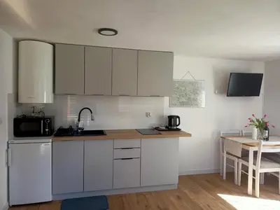 a kitchen with white cabinets and a table at Mogielicki Zakątek in Jurków