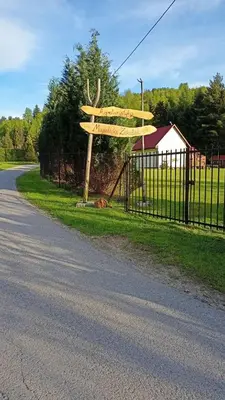 a wooden sign on the side of a road at Mogielicki Zakątek in Jurków