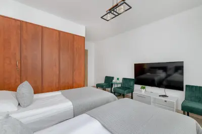 a bedroom with two beds and a flat screen tv at Comfortable Apartment with Balcony in Krakow by Rent like home in Kraków