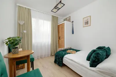 a bedroom with a bed and a desk and a table at Comfortable Apartment with Balcony in Krakow by Rent like home in Kraków