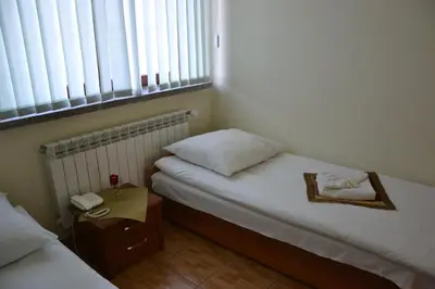 a small bedroom with two beds and a telephone at Zajazd Kwadrat in Dąbrowa Górnicza