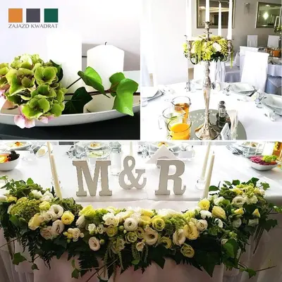 a table with flowers and a m and r sign on it at Zajazd Kwadrat in Dąbrowa Górnicza
