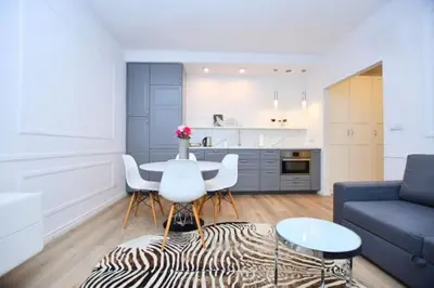 a living room with a table and a blue couch at Elegant apartment in the perfect location in Kraków