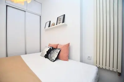 a white bedroom with a bed with pillows on it at Elegant apartment in the perfect location in Kraków