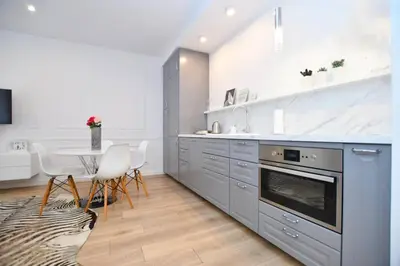 a kitchen with a table and chairs and a counter top at Elegant apartment in the perfect location in Kraków