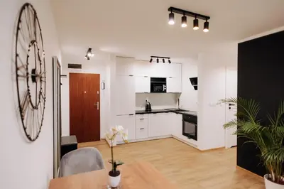 a kitchen with white cabinets and a table in a room at Best of Azory apartment in Kraków
