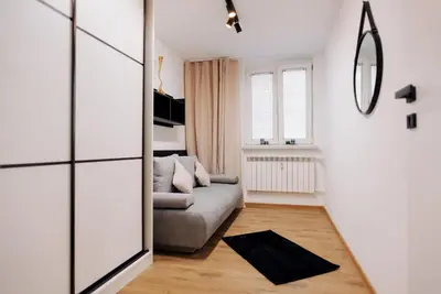 a living room with a couch and a mirror at Best of Azory apartment in Kraków