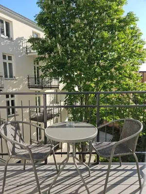 a table and chairs on a patio with a tree at Sage & Timber Apartment Kazimierz in Kraków