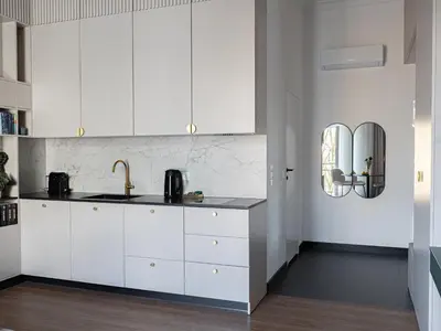 a kitchen with white cabinets and a sink at Sage & Timber Apartment Kazimierz in Kraków