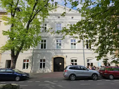 a white building with cars parked in front of it at Sage & Timber Apartment Kazimierz in Kraków