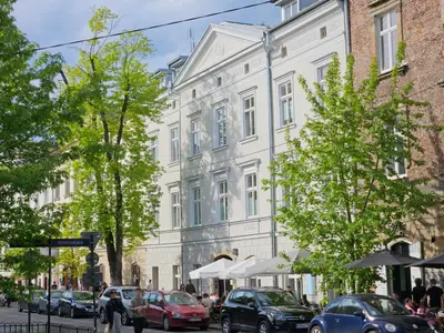 a white building with cars parked on a street at Sage & Timber Apartment Kazimierz in Kraków