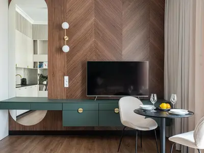 a living room with a green desk with a television at Sage & Timber Apartment Kazimierz in Kraków