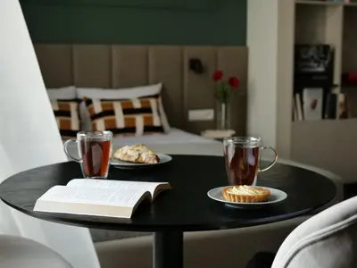 a black table with two cups of tea and a book at Sage & Timber Apartment Kazimierz in Kraków