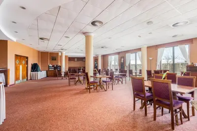 a large room with tables and chairs and windows at Park Zakrzówek Cosy Studio by BookingHost in Kraków