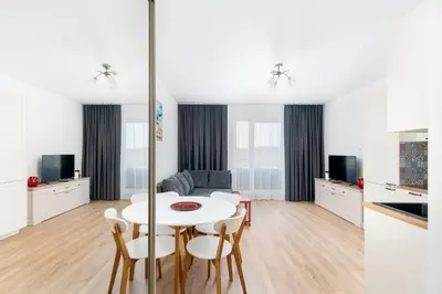 a kitchen and living room with a white table and chairs at Park Zakrzówek Cosy Studio by BookingHost in Kraków