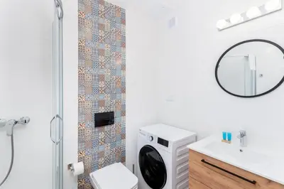 a bathroom with a shower and a toilet and a mirror at Park Zakrzówek Cosy Studio by BookingHost in Kraków