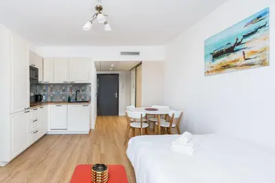 a room with a bed and a table and a kitchen at Park Zakrzówek Cosy Studio by BookingHost in Kraków