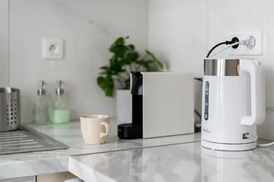 a kitchen counter with a coffee maker and a laptop at Malila Premium Apartments City Center Kazimierz Starowiślna 41 in Kraków