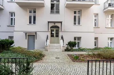a white house with a green door at Malila Premium Apartments City Center Kazimierz Starowiślna 41 in Kraków
