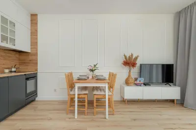 a kitchen with a table and chairs and a television at Cozy Apartment Orawska with Balcony by Noclegi Renters in Kraków
