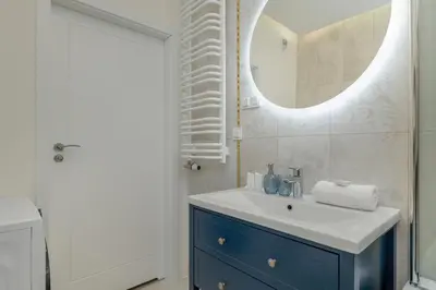 a bathroom with a sink and a mirror at Cozy Apartment Orawska with Balcony by Noclegi Renters in Kraków