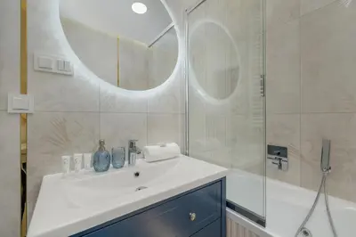 a bathroom with a sink and a shower with a mirror at Cozy Apartment Orawska with Balcony by Noclegi Renters in Kraków