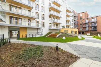 an apartment complex with a lawn in front of a building at Cozy Apartment Orawska with Balcony by Noclegi Renters in Kraków