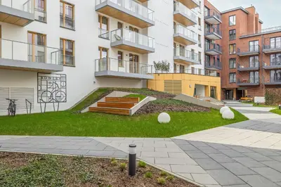 a grassy area in the middle of a building at Cozy Apartment Orawska with Balcony by Noclegi Renters in Kraków