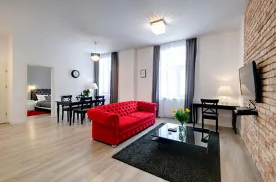 a living room with a red couch and a table at Zamkowa15 Apartments in Kraków