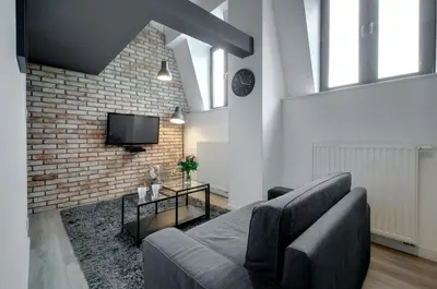 a living room with a couch and a brick wall at Zamkowa15 Apartments in Kraków