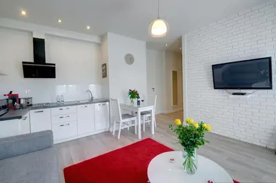 a kitchen and a living room with a red rug at Zamkowa15 Apartments in Kraków