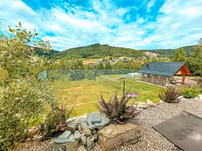 a view of a garden with a house and a field at ForRest House Jacuzzi & Sauna in Jasienica