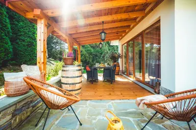 a screened in porch with two chairs and a table at ForRest House Jacuzzi & Sauna in Jasienica