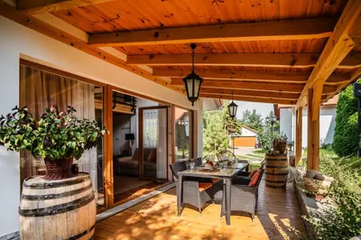 a patio with a table and chairs and a wooden ceiling at ForRest House Jacuzzi & Sauna in Jasienica