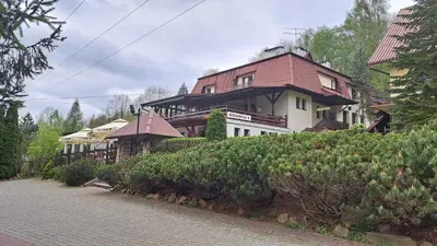 a large house with a red roof on a hill at Zajazd-restauracja Zyga in Iwkowa