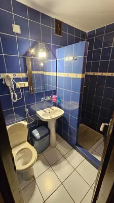 a blue tiled bathroom with a toilet and a sink at Zajazd-restauracja Zyga in Iwkowa