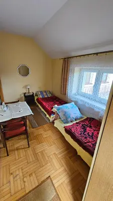 a room with two beds and a table and a window at Zajazd-restauracja Zyga in Iwkowa