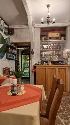 a dining room with a table and a kitchen at Zajazd-restauracja Zyga in Iwkowa
