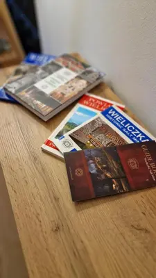 a group of books sitting on top of a wooden table at Underground Cave Apartment in Wieliczka