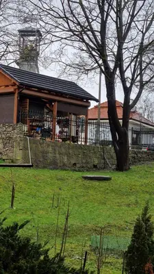 a building with a tree in front of a field at Underground Cave Apartment in Wieliczka